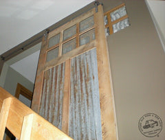 rusty corrugated metal panels and decorative glass in reclaimed wood door